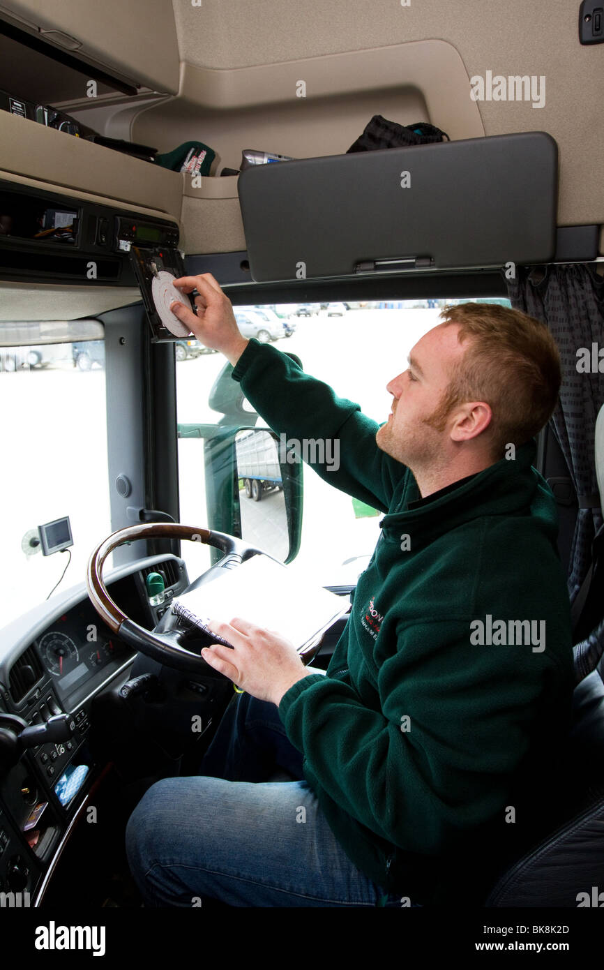 A Lorry driver changing a tachograph card in his cab Stock Photo