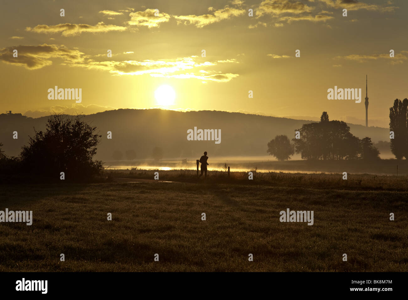 A jogger at the banks of river Elbe in Dresden, Germany, at sunrise Stock Photo