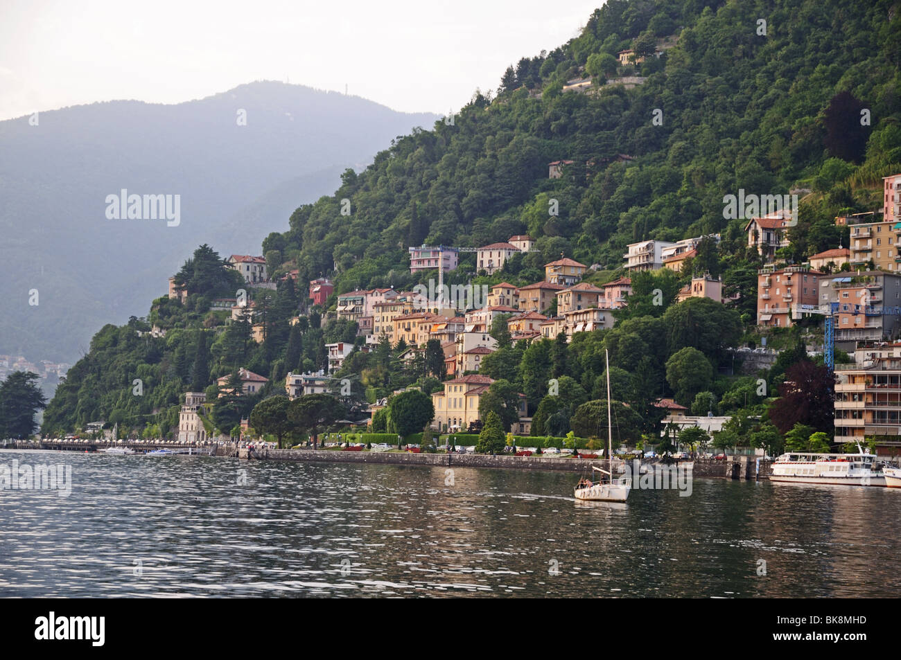 Como lake with houses and yatch seen from Lungolario or lungo lago promenade Italy Stock Photo