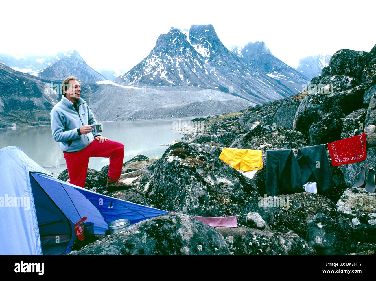 Photographer H. Mark Weidman drying out wet clothing on a backpacking trip in Auyuittuq National Park, Nunavut, Canada Stock Photo