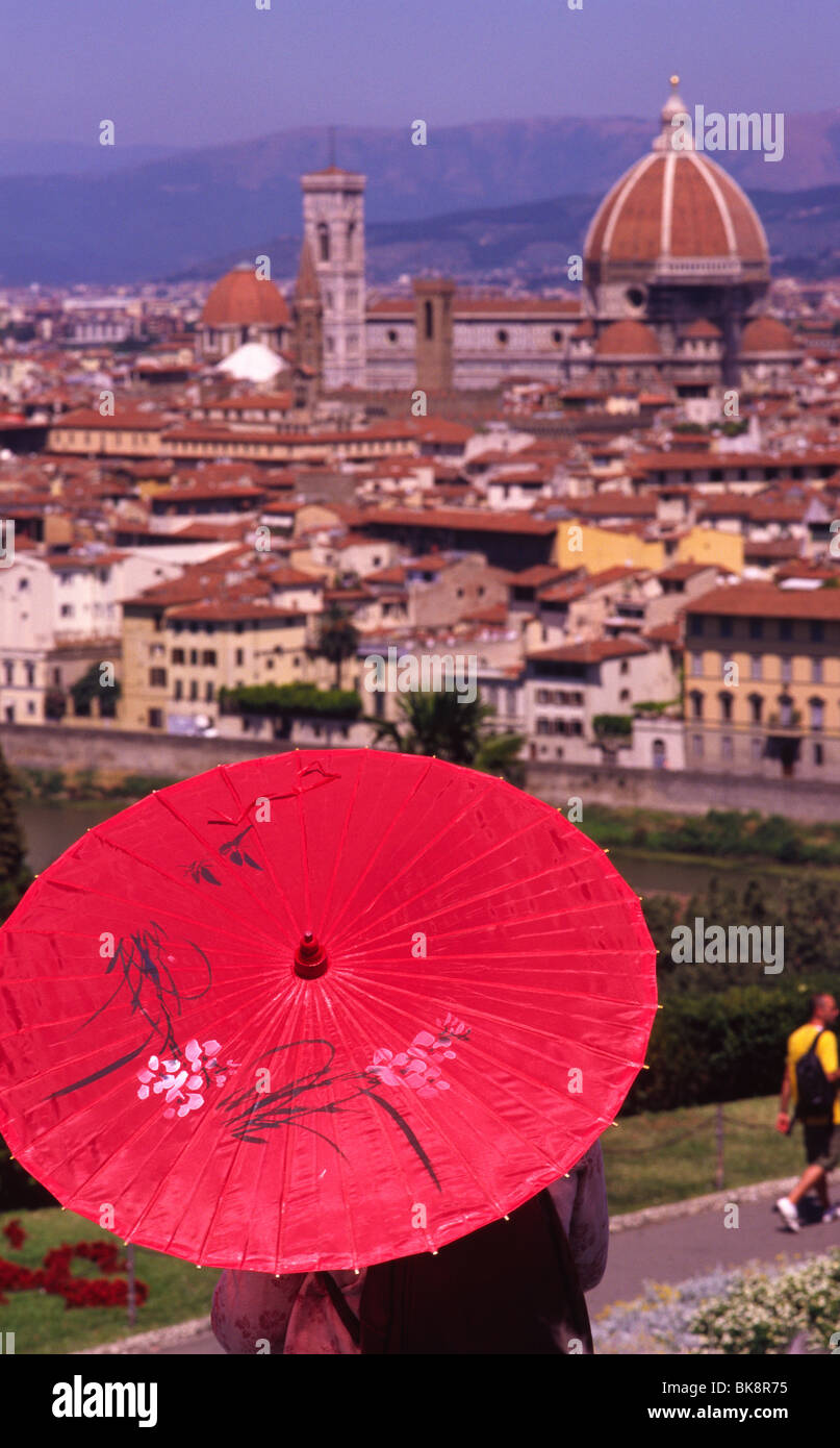 Florence, July 2008 -- Tourist shields herself from the sunlight with an umbrella. In the background: Basilica di Santa Maria de Stock Photo
