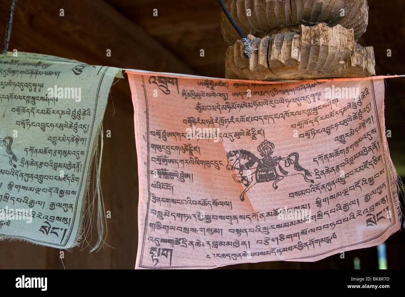 Buddhist prayer flags hung under the eaves of an old Tibetan farmhouse in Zharu valley in Jiuzhaigou in Sichuan in China. Stock Photo