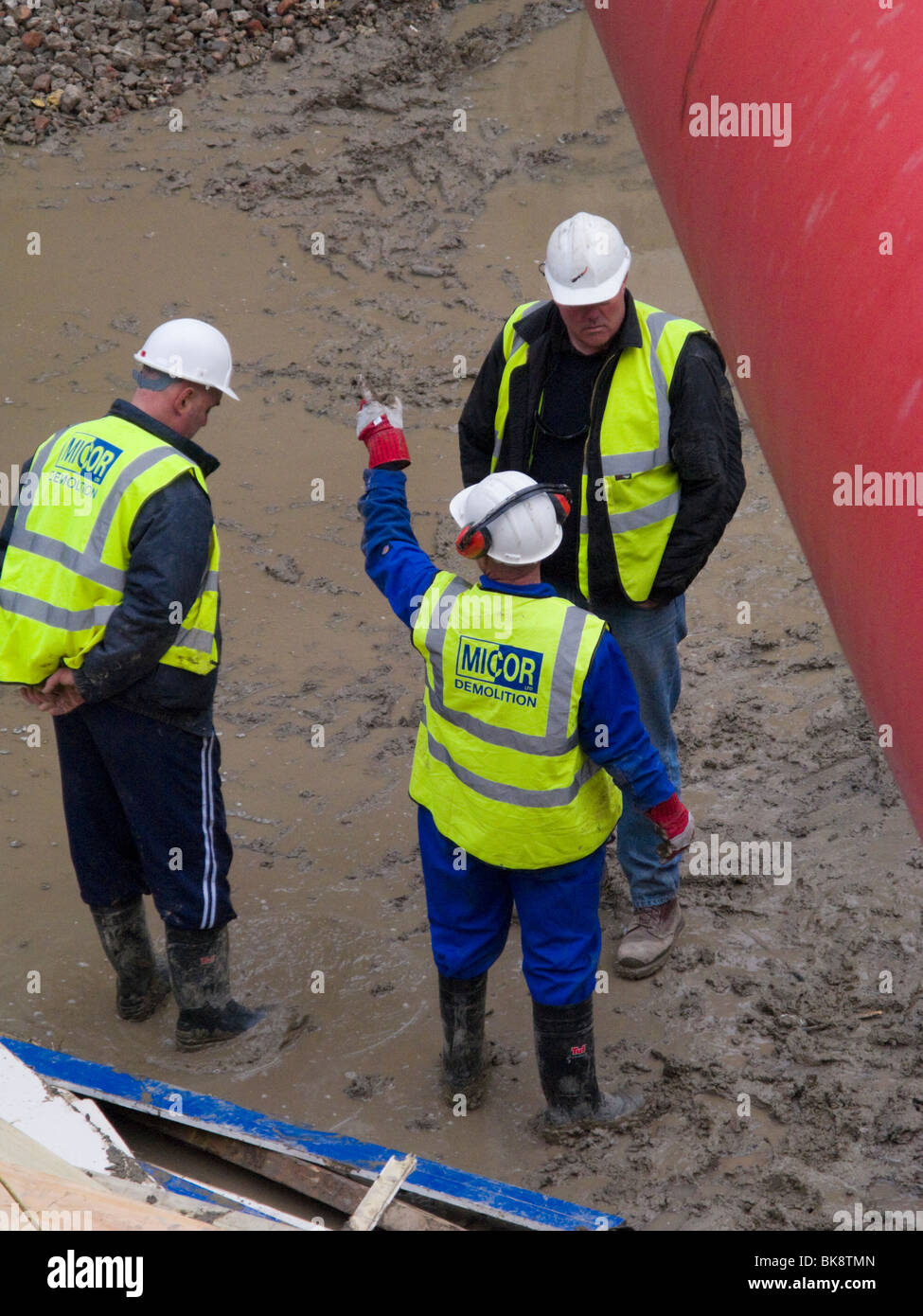 Construction workers with hard hats and high visibility vests talking