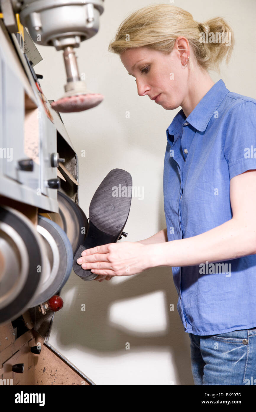 Shoemaker grinding the sole of the shoe Stock Photo