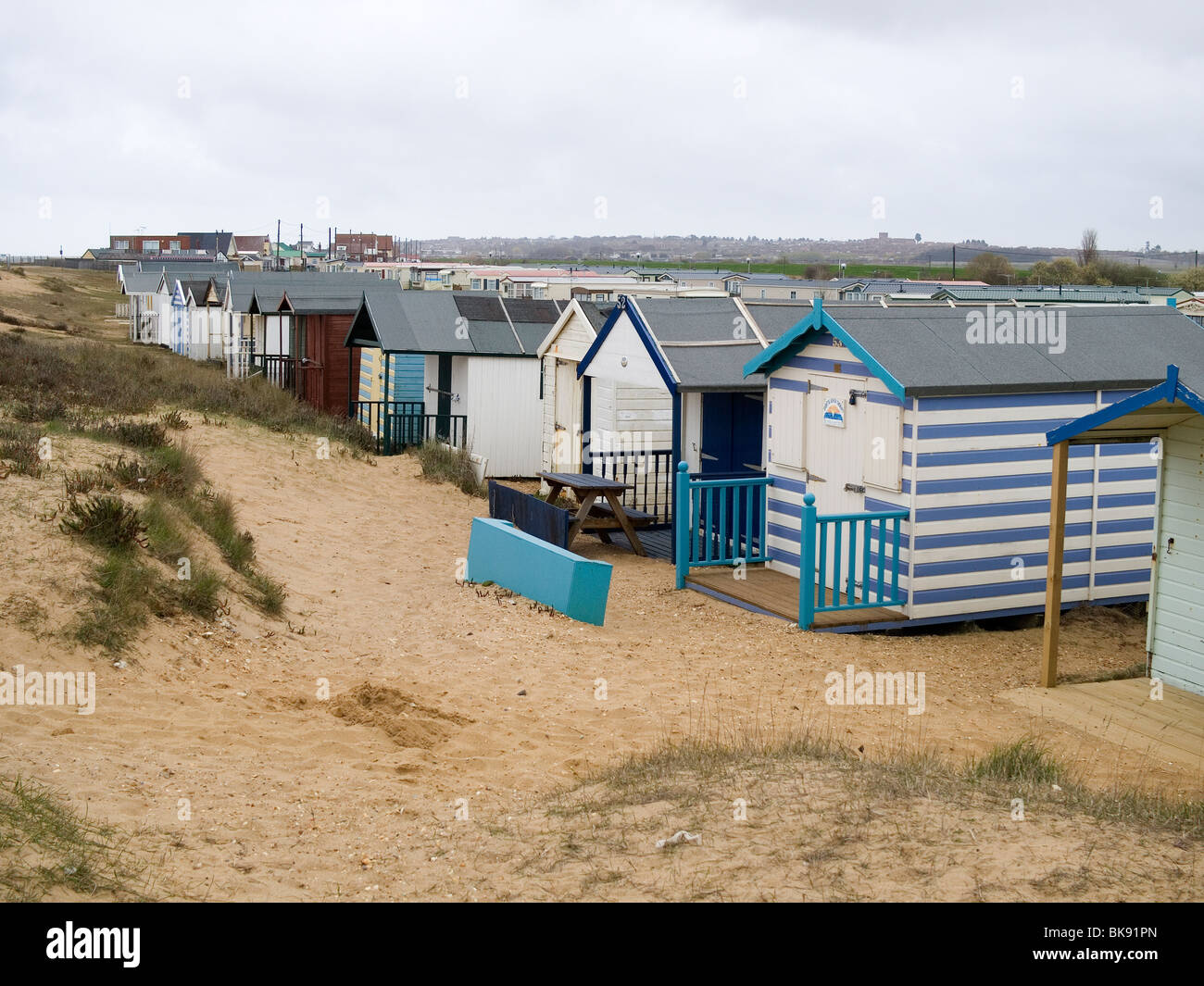 Deserted drab out of season beach huts and caravan park at Heacham West Norfolk Stock Photo