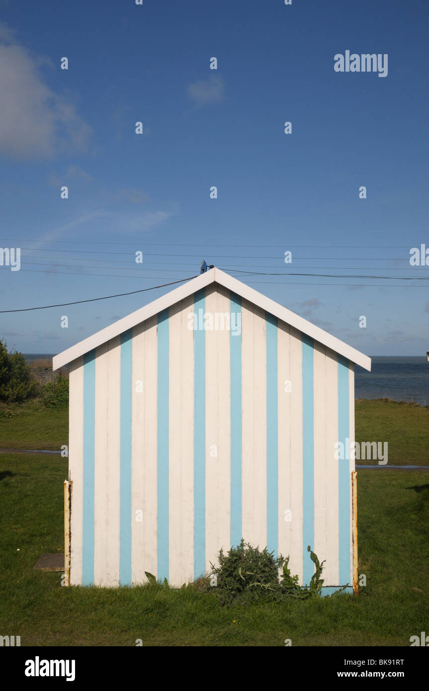Blue and white striped beach hut at Westward Ho, Devon, UK Stock Photo