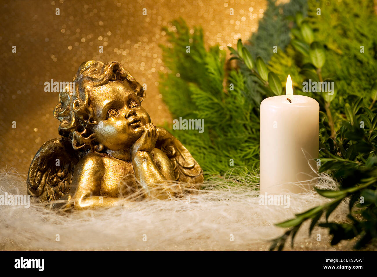 Angel and a burning white candle Stock Photo