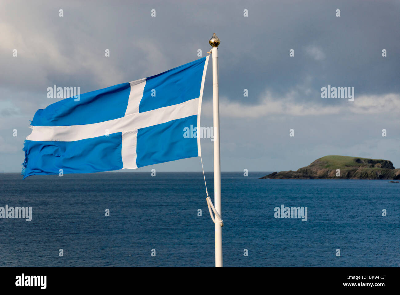 Flag of Scotland, in the back an island, Scotland, United Kingdom, Europe Stock Photo