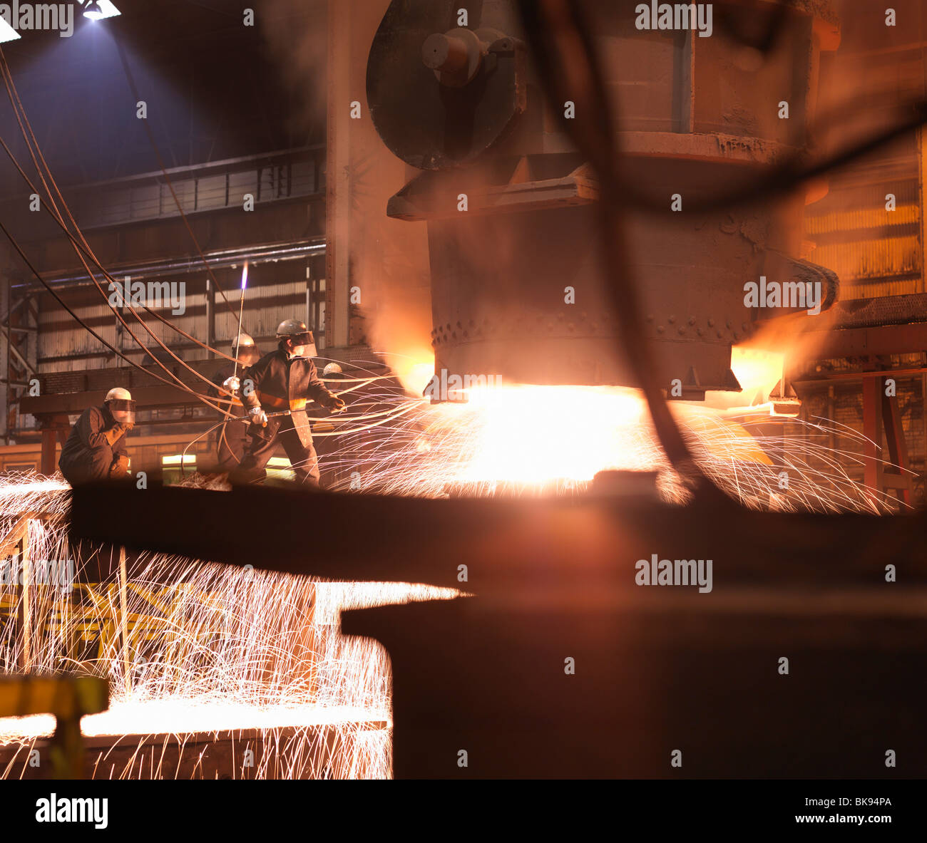 Workers Pouring Molten Steel In Plant Stock Photo