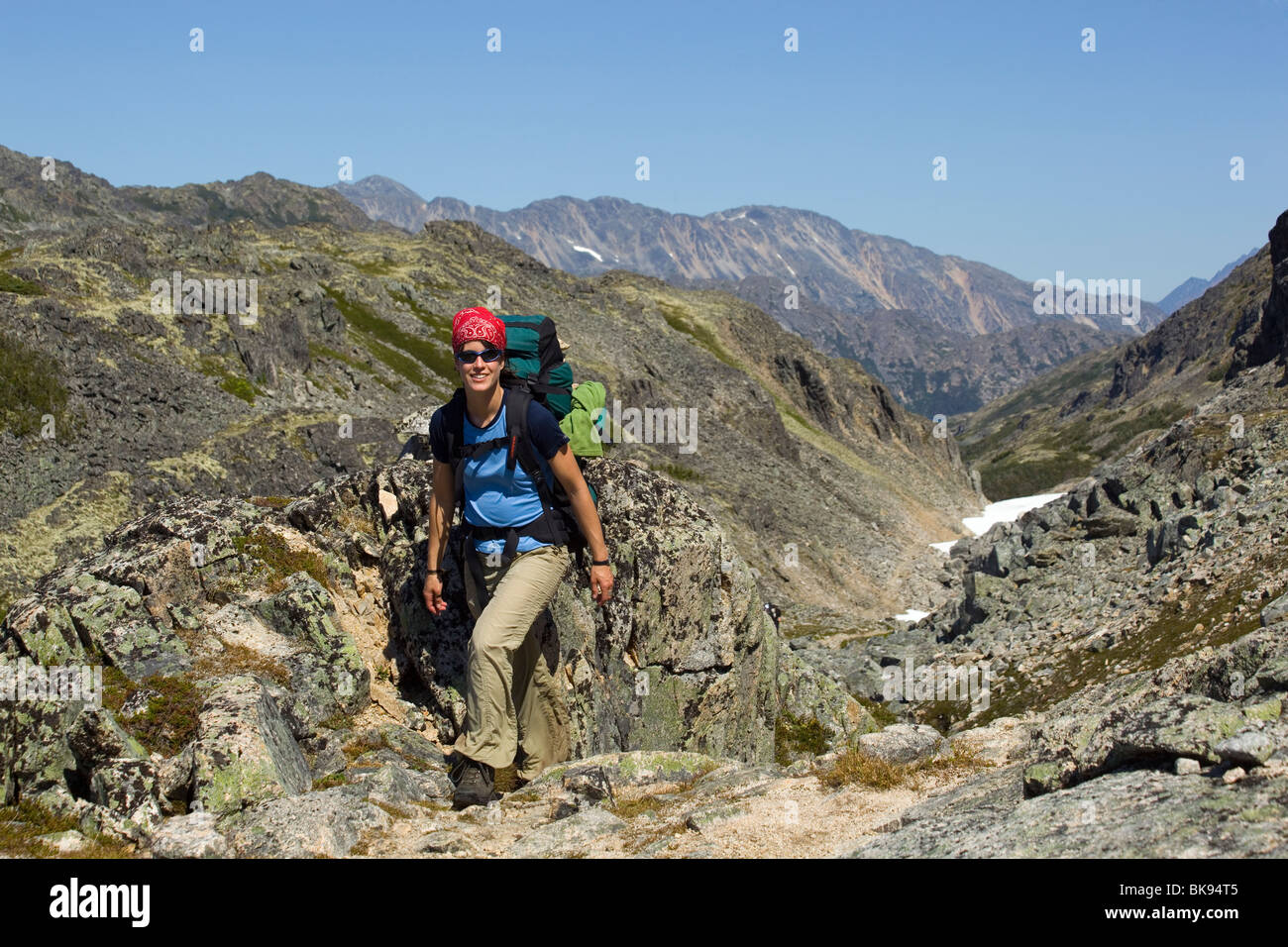 Young woman hiking, backpacking through rocks, hiker with backpack, historic Chilkoot Pass, Chilkoot Trail, Yukon Territory, Br Stock Photo