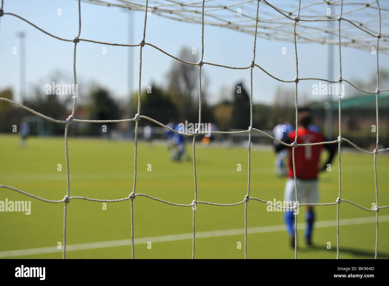 A close up of a football goal netting with sunshine backlighting the