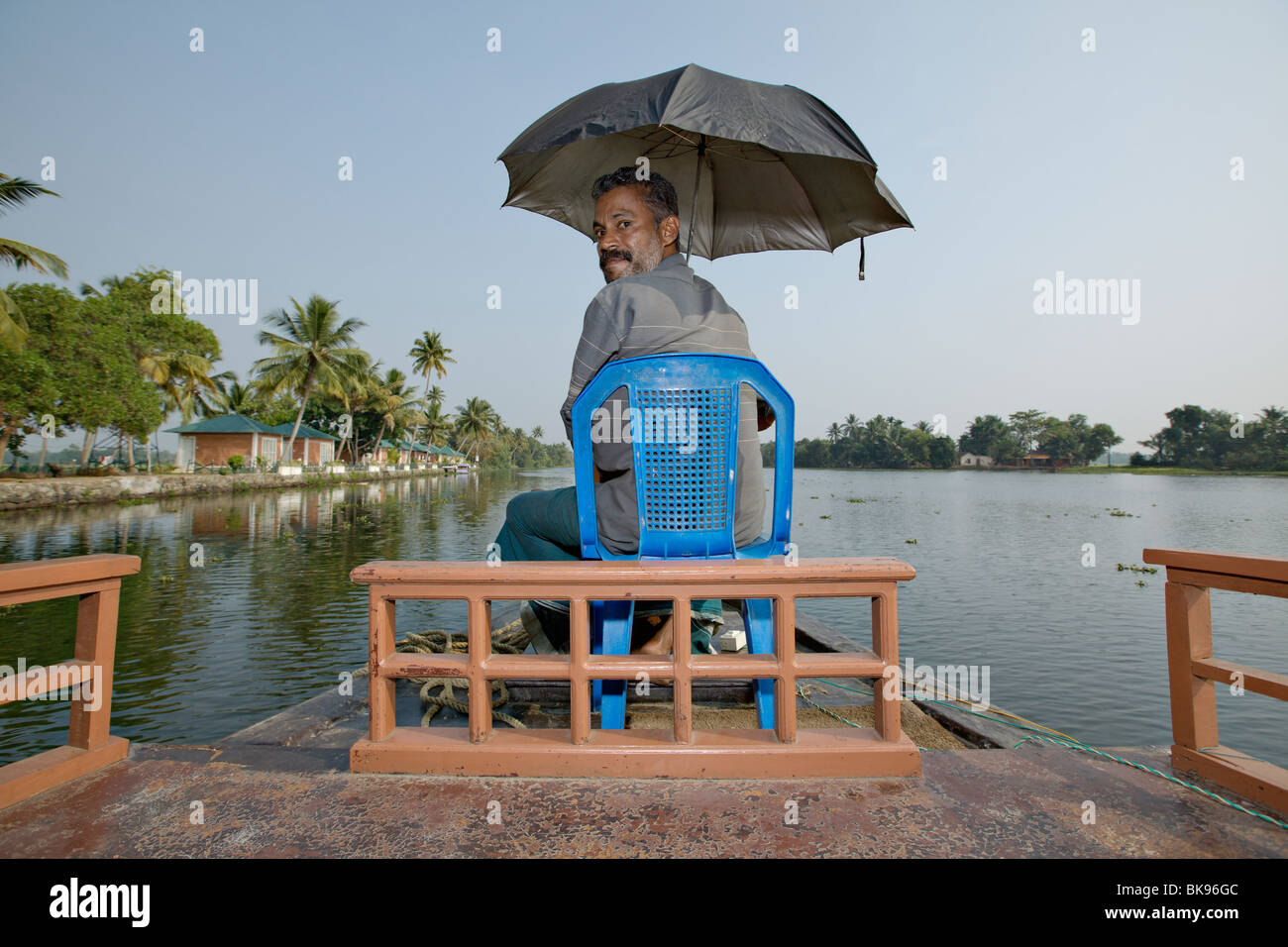 Houseboat captain steering his traditional style kettuvallam boat in