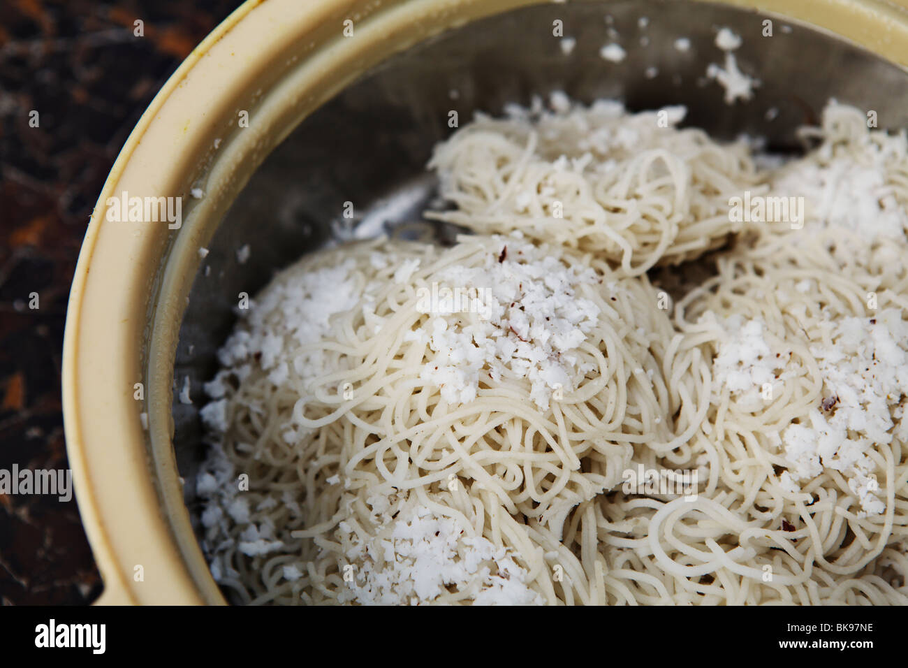 Idiyappam is a steamed rice noodle cake with coconut flakes on the top