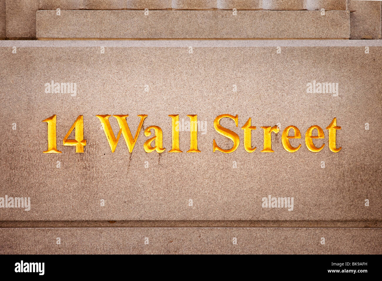Wall Street sign engraved on the wall of a bank building along Wall Street, Lower Manhattan, New York City USA Stock Photo