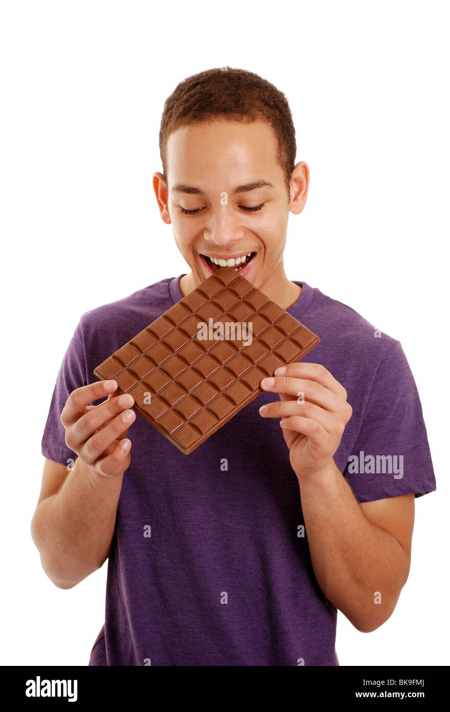 Boy biting a large bar of chocolate Stock Photo