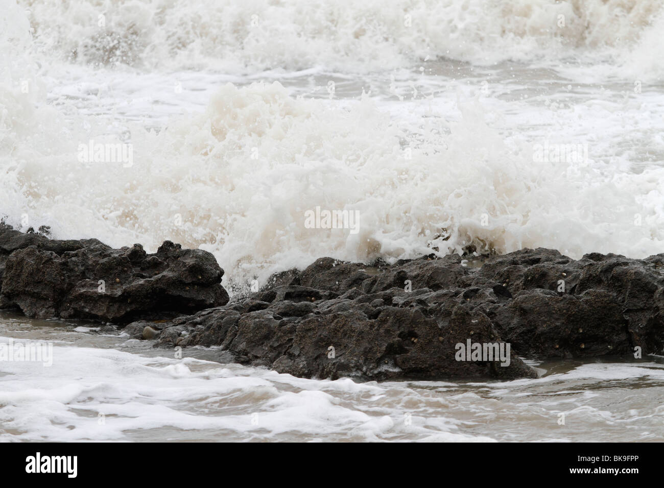 Atlantic breakers on the beach at Porthcawl running alongside the Esplanade. Waves on the rocks Stock Photo