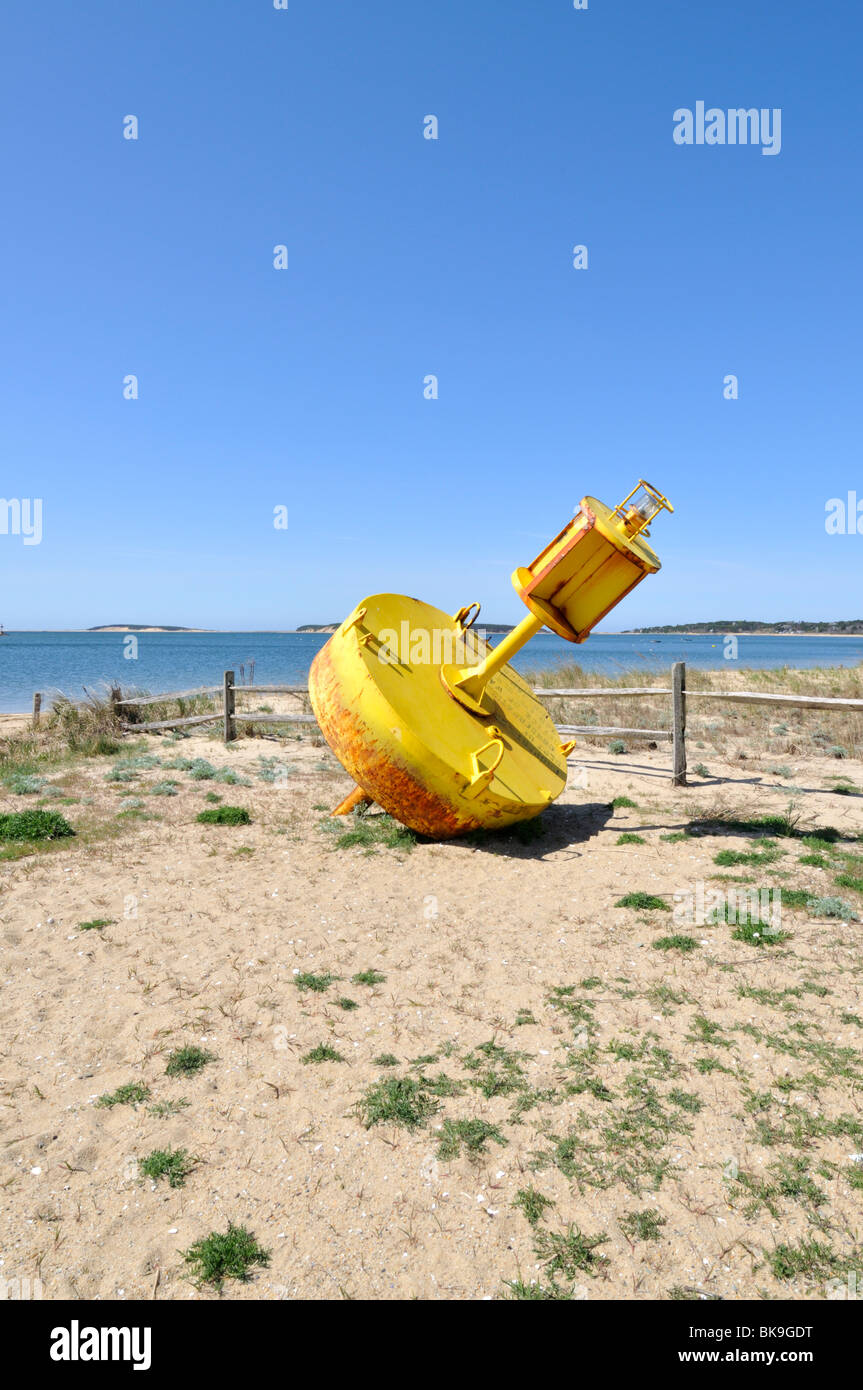 Yellow channel marker beached  in Wellfleet Harbor, Cape Cod USA. Stock Photo