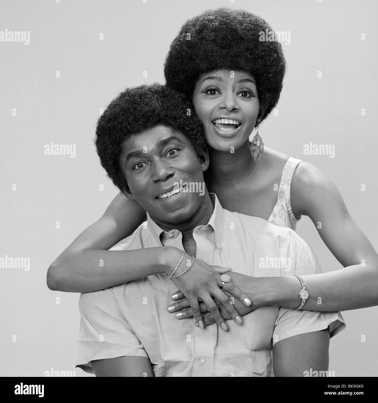Portrait of a young woman embracing a young man from behind Stock Photo ...