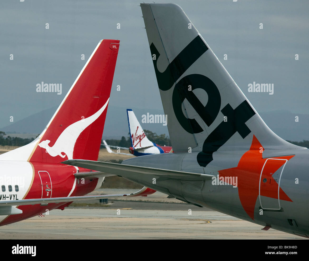 Tails of budget airline and Qantas aircraft at an Australian airport Stock Photo
