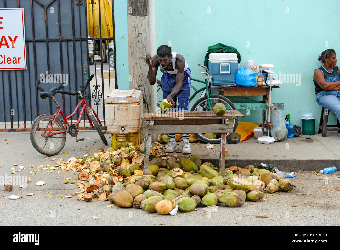 Native man sells coconuts at roadside stand native man male black