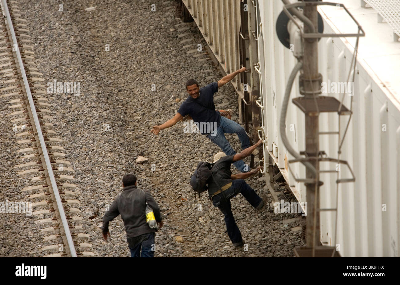 Undocumented Central American migrants traveling across Mexico to work in the United States jump a cargo train in Mexico City Stock Photo