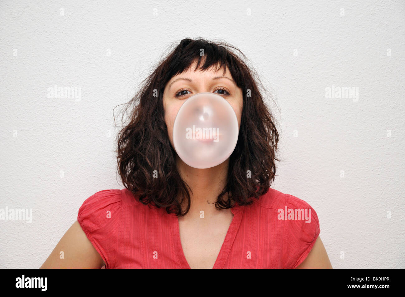 Young woman blowing bubble gum Stock Photo - Alamy