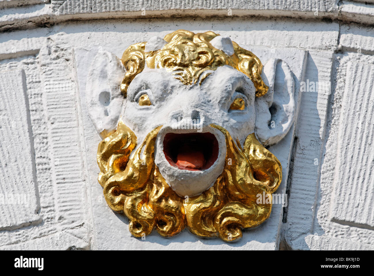 Head of a mythical creature with an open mouth and a golden beard, facade relief on a city palace from the 17th century, Hoorn, Stock Photo