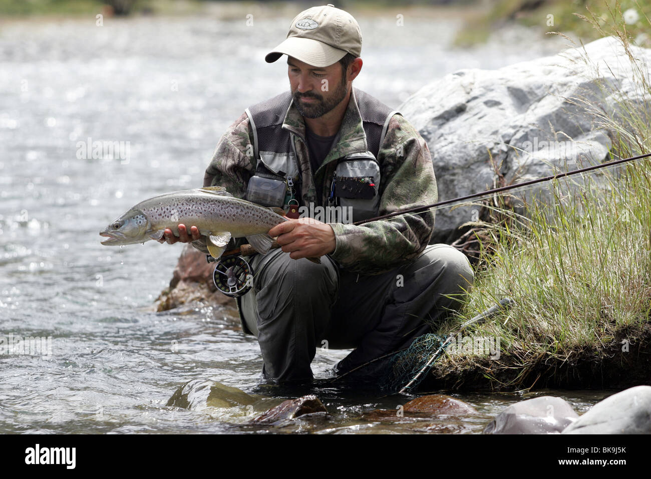 Nelson guide Mike Kirkpatrick releases a brown trout while fly fishing