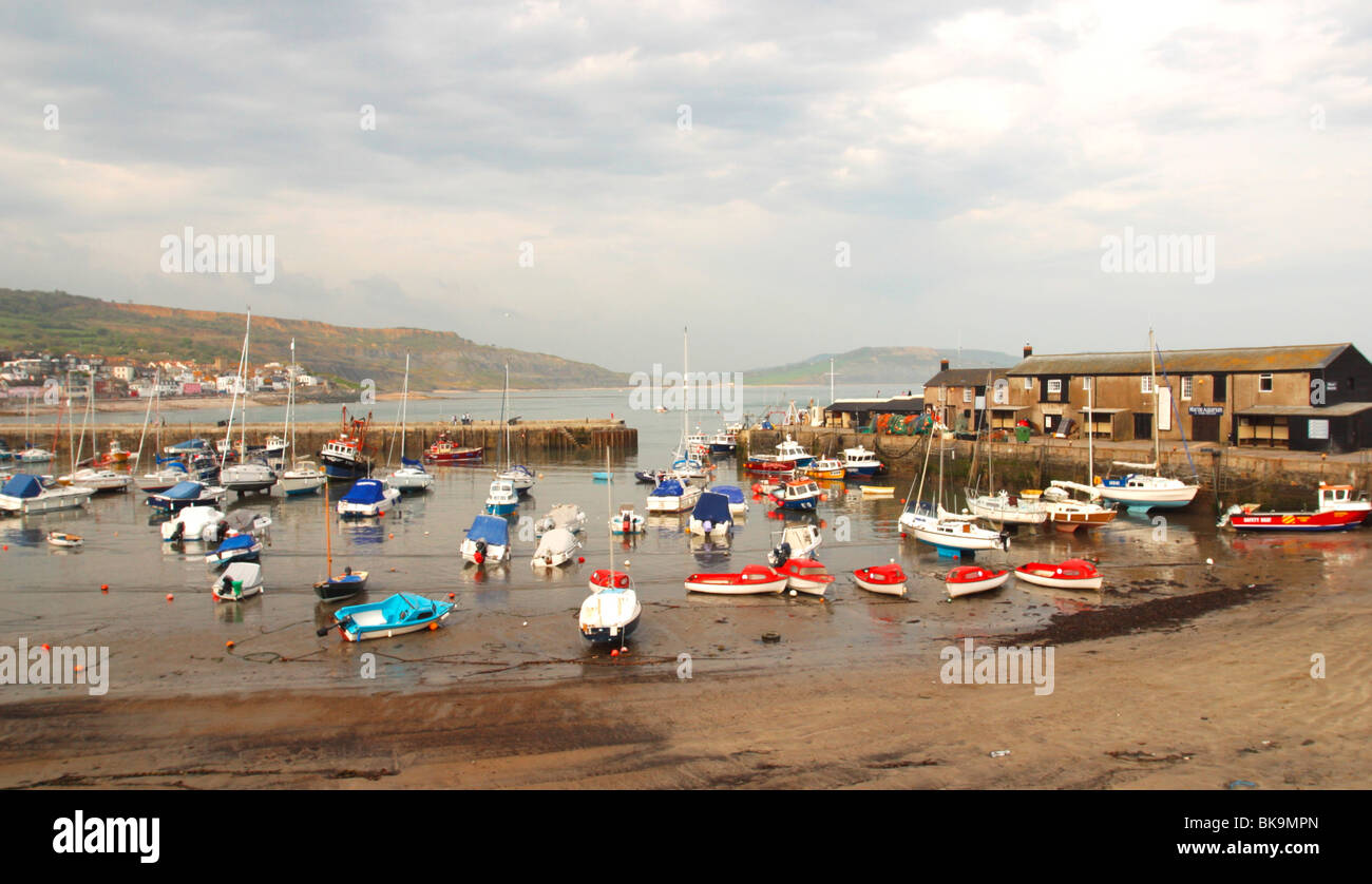 Boats inside walls Lyme Regis harbour harbor built to protect ships from rough weather on English Channel in Dorset Wessex Stock Photo