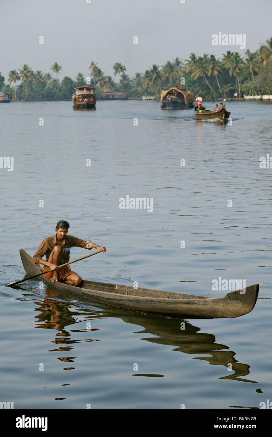 Man with his dugout canoe in backwaters of Kerala, India. Stock Photo