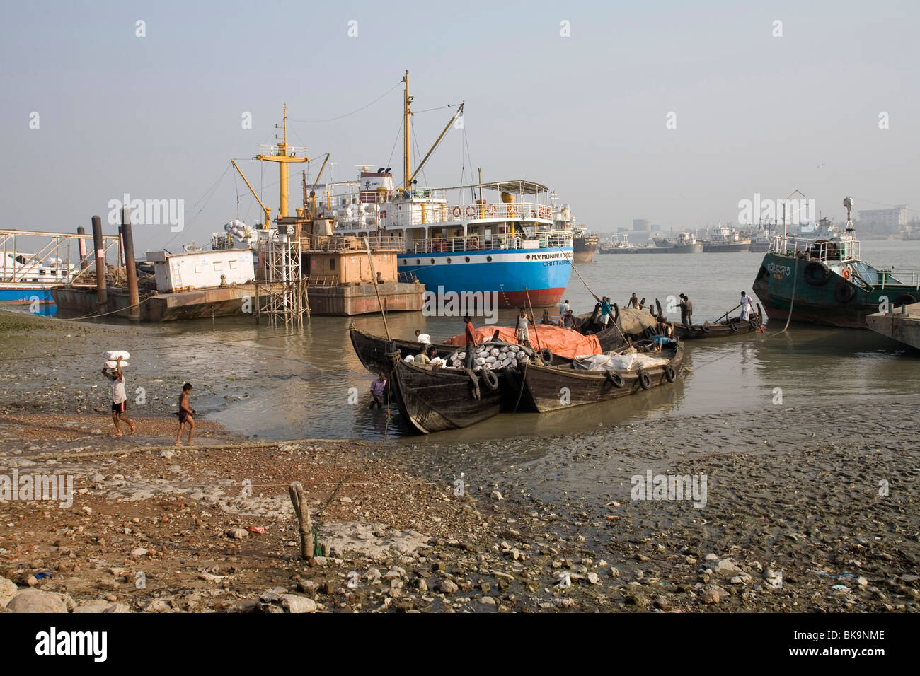 Workers unload cargo from a ship to a waiting lorry in the docks at Sadarghat, Chittagong, Bangladesh Stock Photo