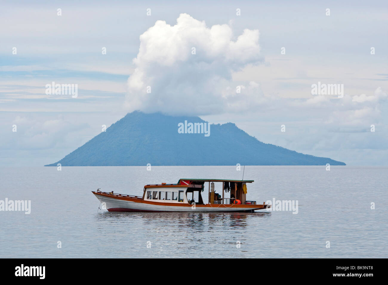 Diving boat in the Bunaken Marine Park in front of Mt Manado Tua, North Sulawesi, Indonesia Stock Photo