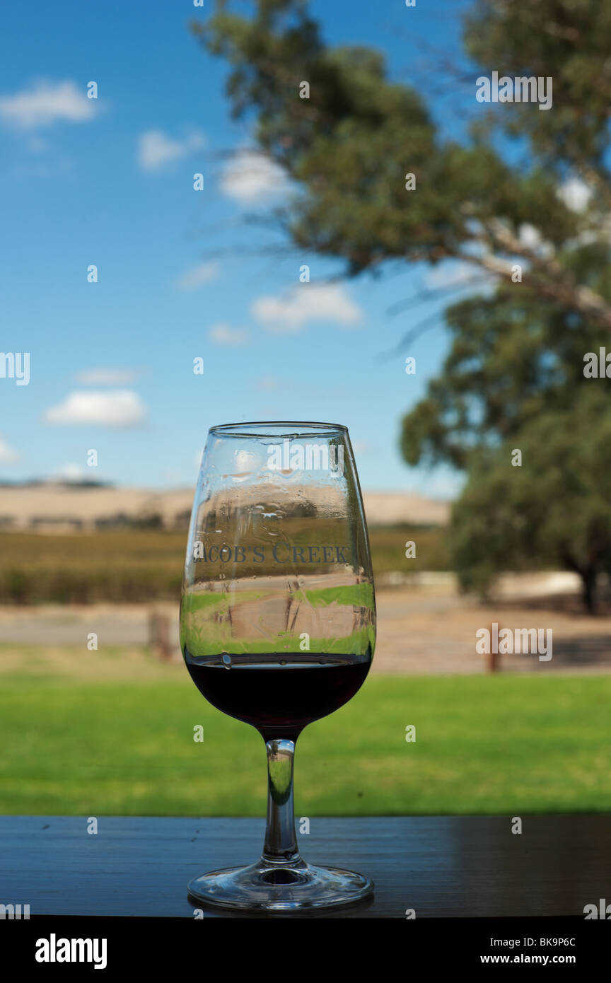 Red wine in a tasting glass at Jacob's Creek Visitor Centre, with the Barossa Valley in the background, South Australia Stock Photo