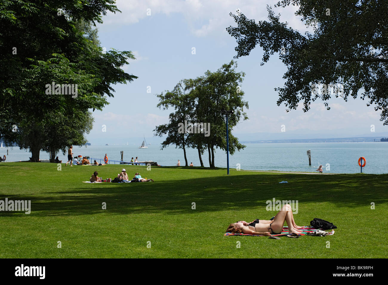 People sunbathing at lake Constance, Uberlingen, Baden-Wurttemberg, Germany Stock Photo