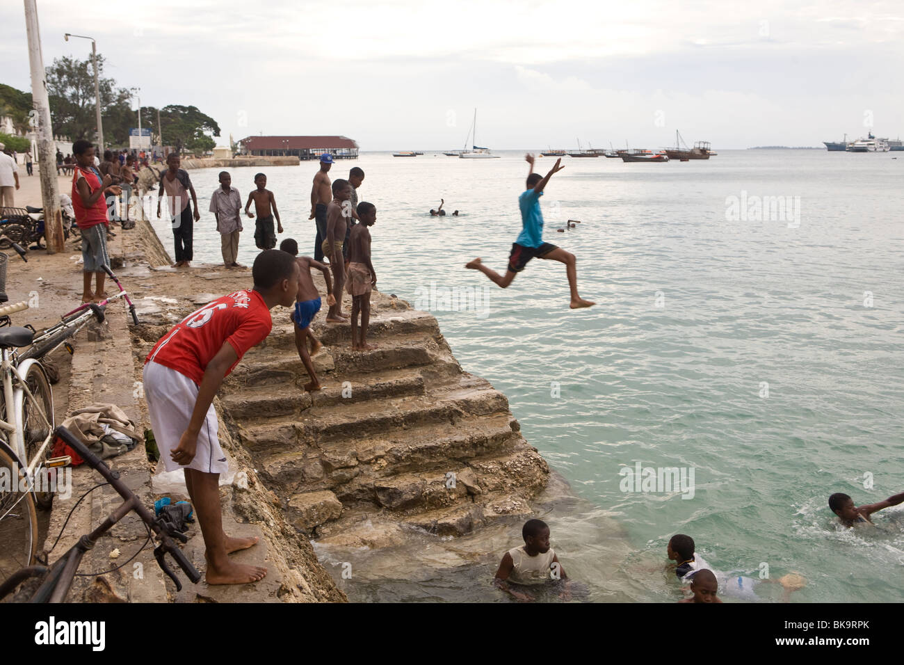 Boys swimming in the harbour - Stonetown, Zanzibar, Tanzania. Stock Photo