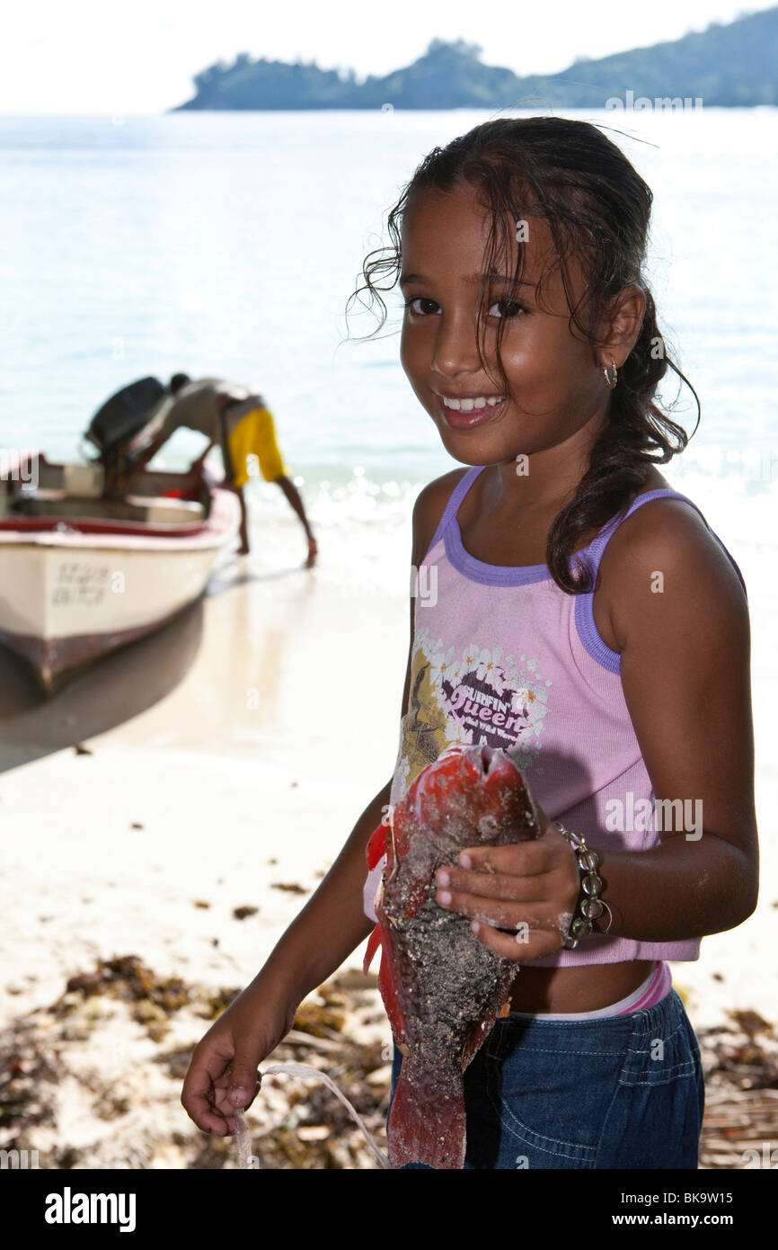 Young Creole girl, about 9 years old, holding freshly caught parrot fish,  Baie Lazare, Mahe Island, Seychelles, Indian Ocean, A Stock Photo - Alamy