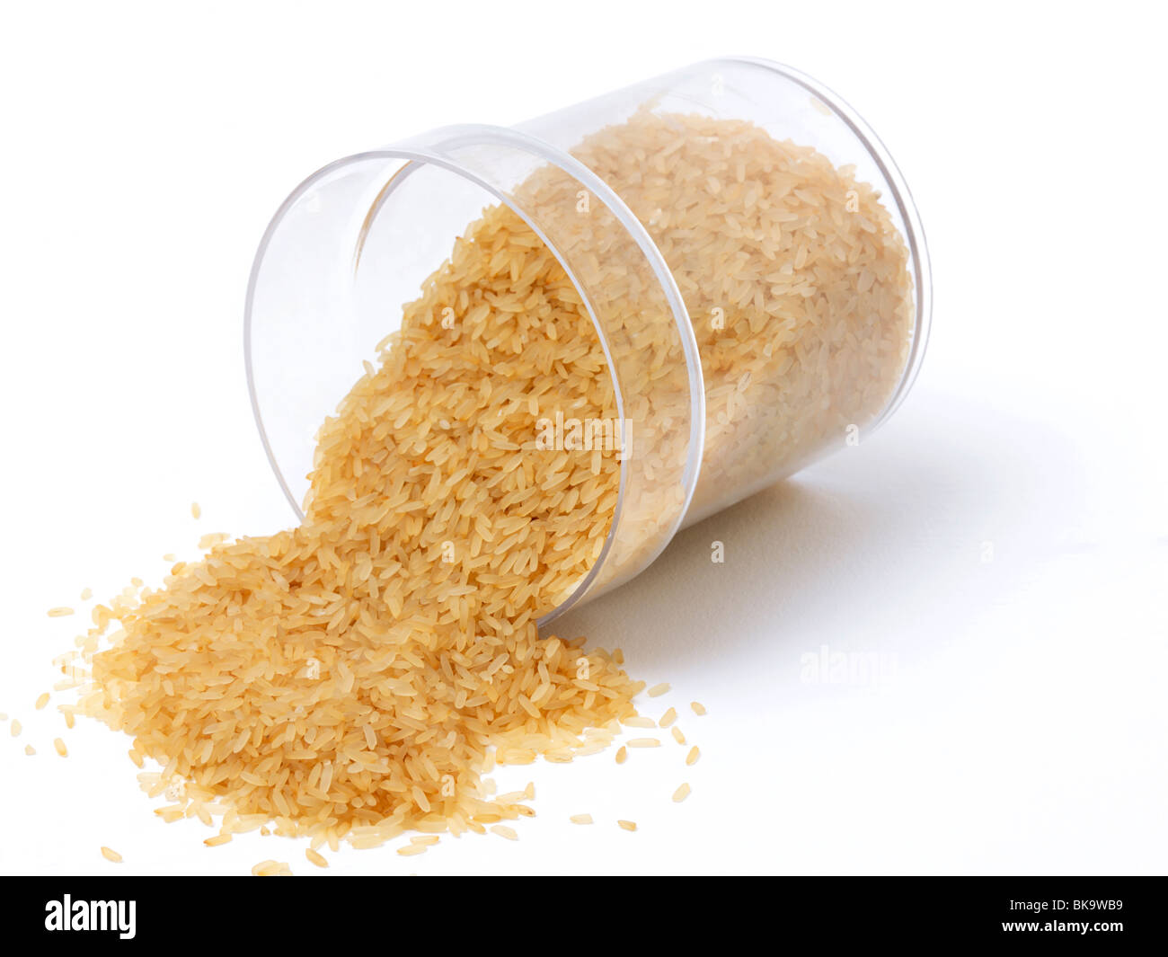 Uncooked Rice Spilling Out Of Plastic Container Stock Photo