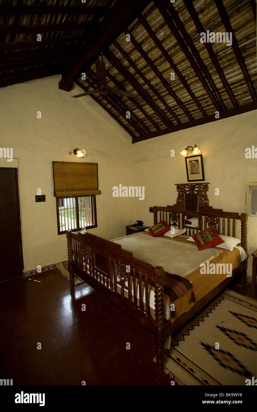 The Guest bedroom's blue velvet backdrop, adorned with striking gold  accents, aim to create a dramatic focal point amidst minimal white walls  and sleek wardrobe laminates. Abstract bird lighting suspended above the, image size:866x1390