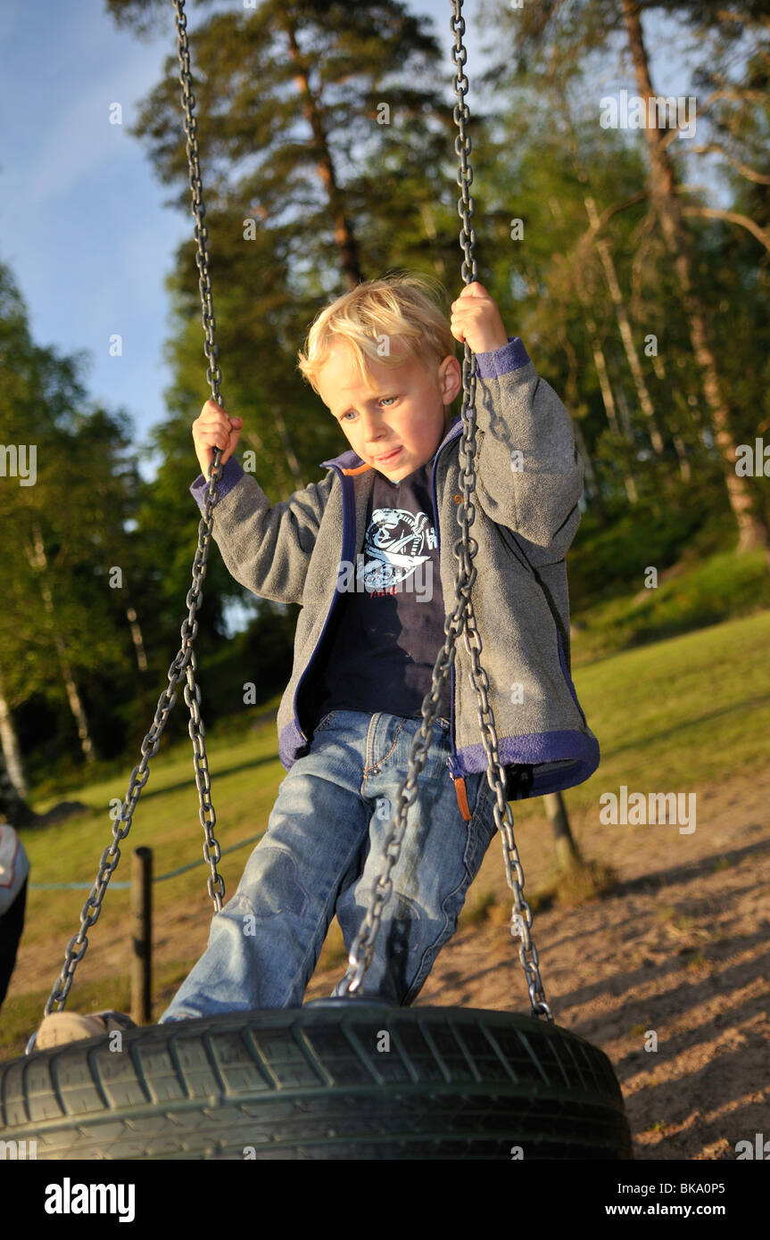Boy on swing, Norrkoeping, Ostergotlands Lan, Sweden Stock Photo
