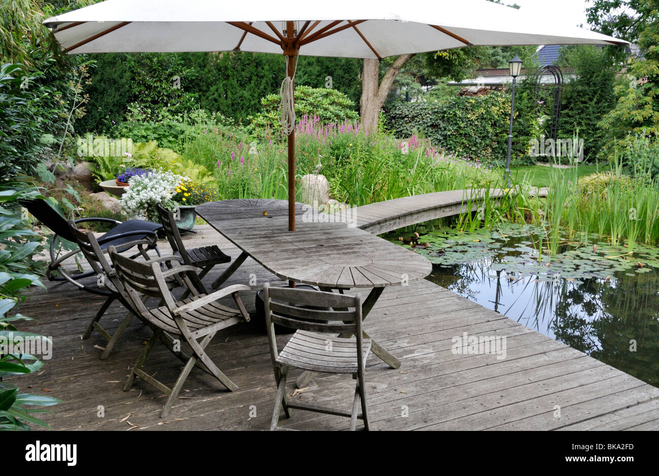 Wooden decking area with seats at a swimming pond Stock Photo