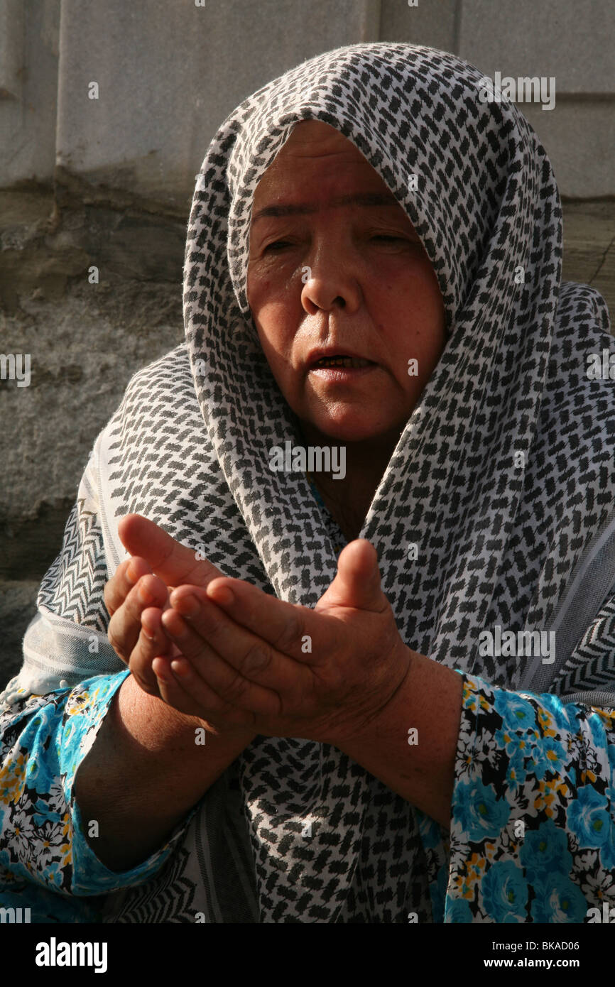 Uzbek woman prays at the mausoleum of Baha-ud-Din Naqshband Bukhari near Bukhara, Uzbekistan. Stock Photo