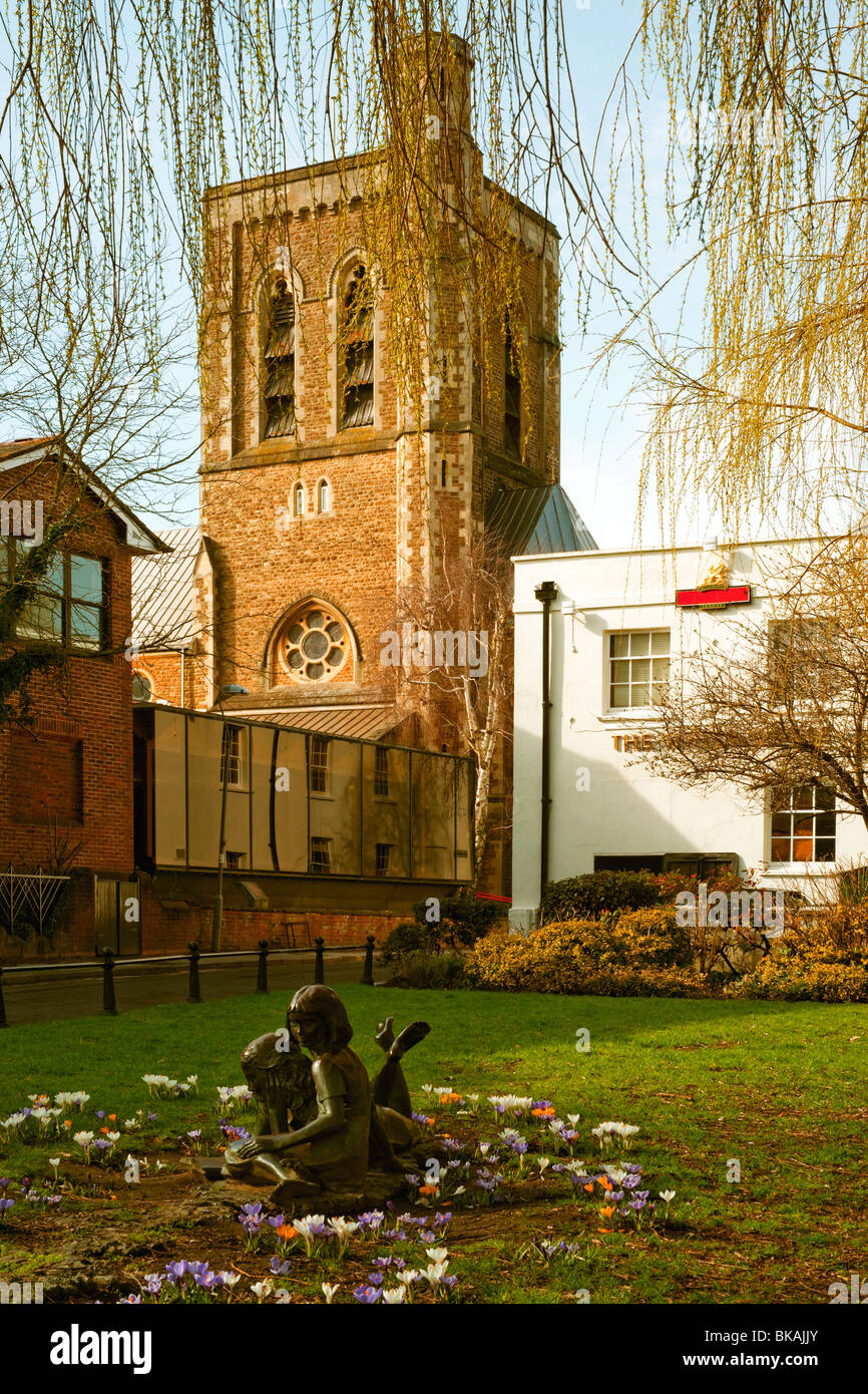 Bronze statue with looking glass and church tower Stock Photo