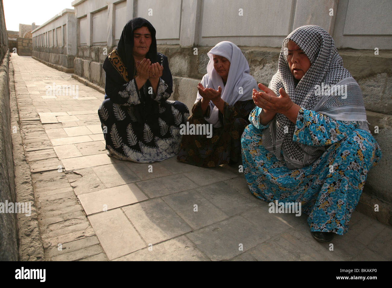 Uzbek women pray at the mausoleum of Baha-ud-Din Naqshband Bukhari near Bukhara, Uzbekistan. Stock Photo