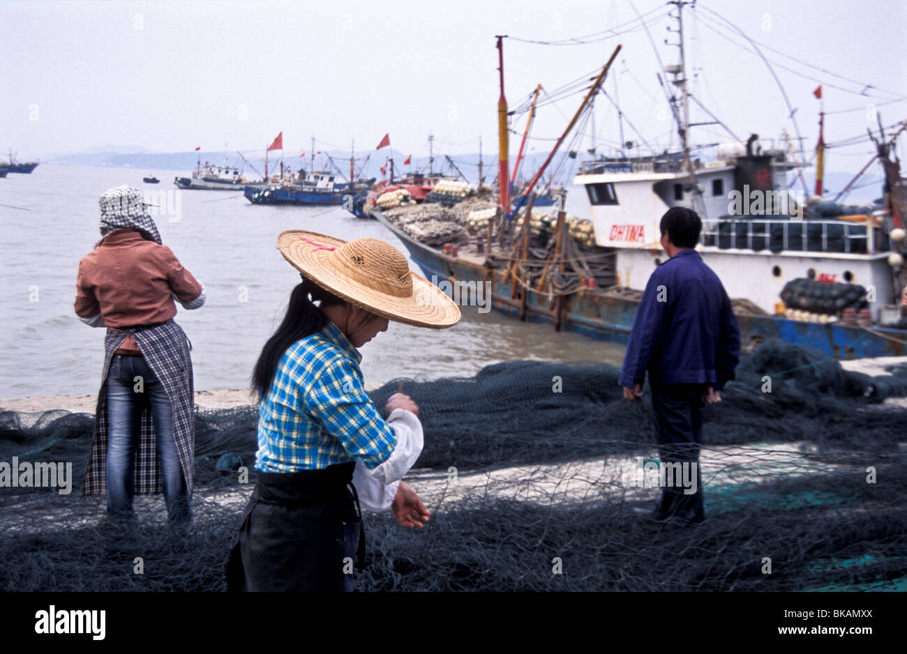 Villagers repair nets in the harbour of Jin Shan Island, China Stock Photo  - Alamy