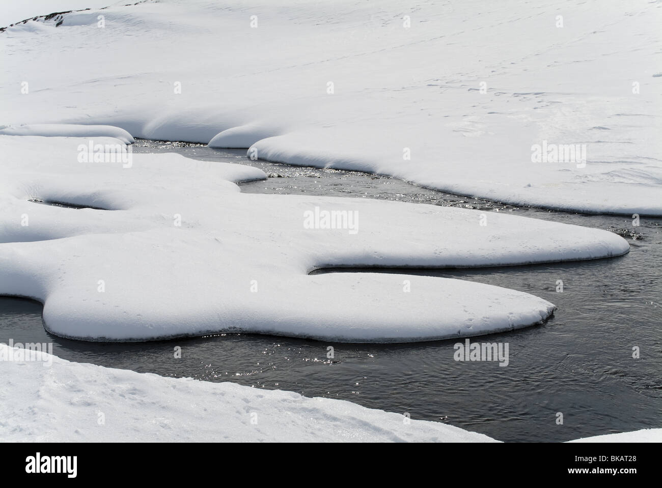 curvaceous melted ice in snowy landscape Finland Lappland Stock Photo