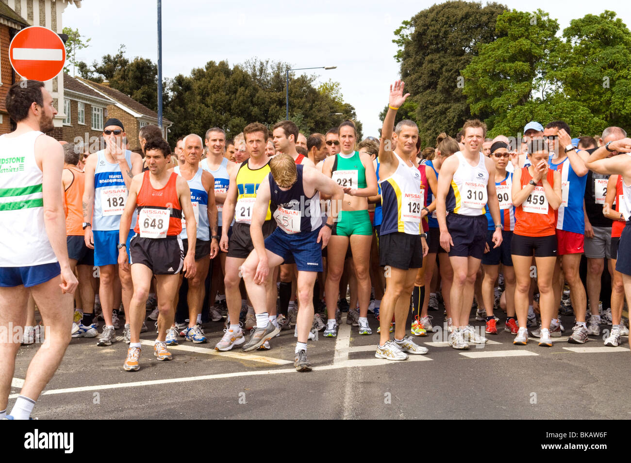 Groups of runners collecting in the road prior to the start of a 10KM