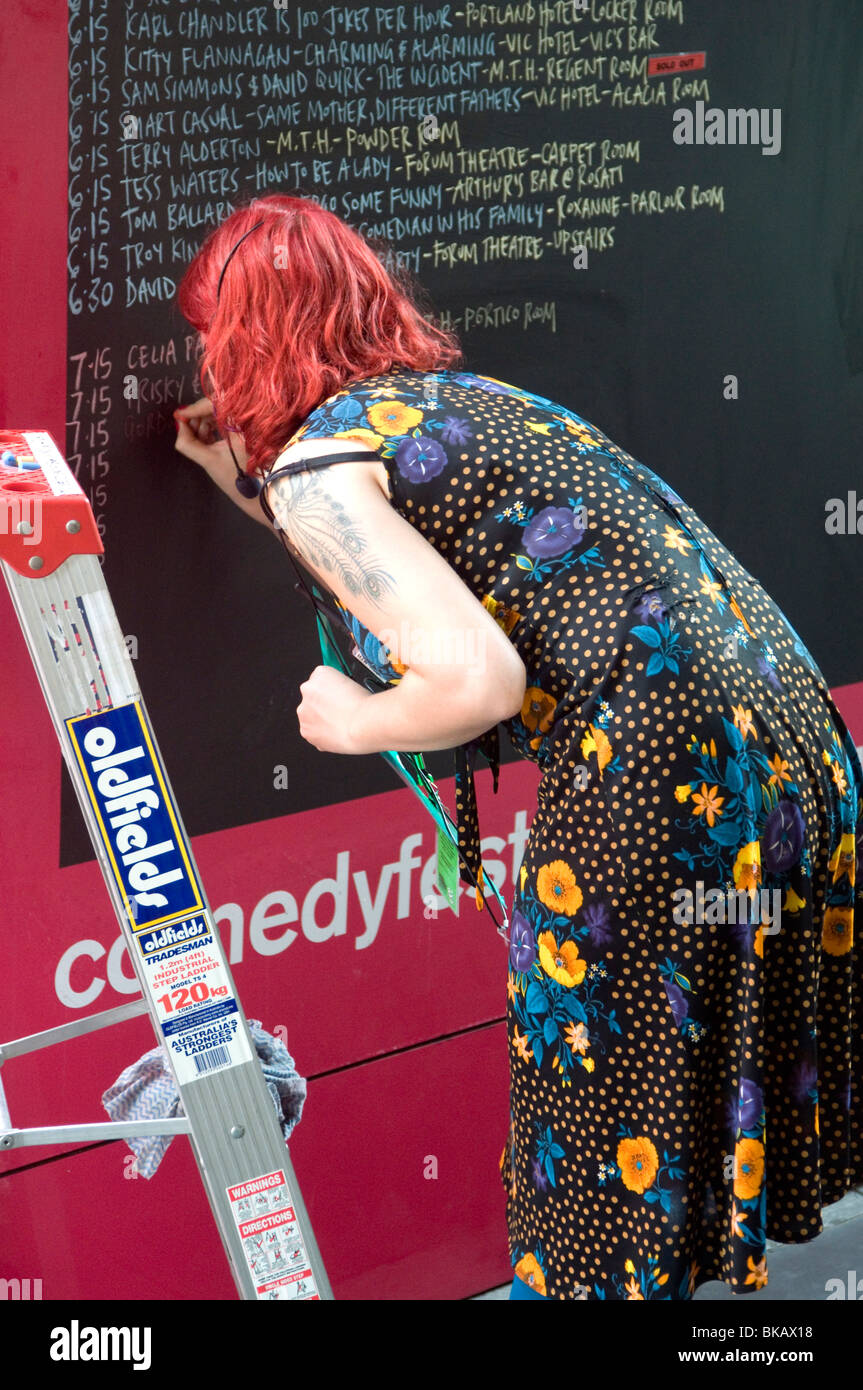 A Melbourne International Comedy Festival organiser writes up the daily program outside Melbourne Town Hall Stock Photo