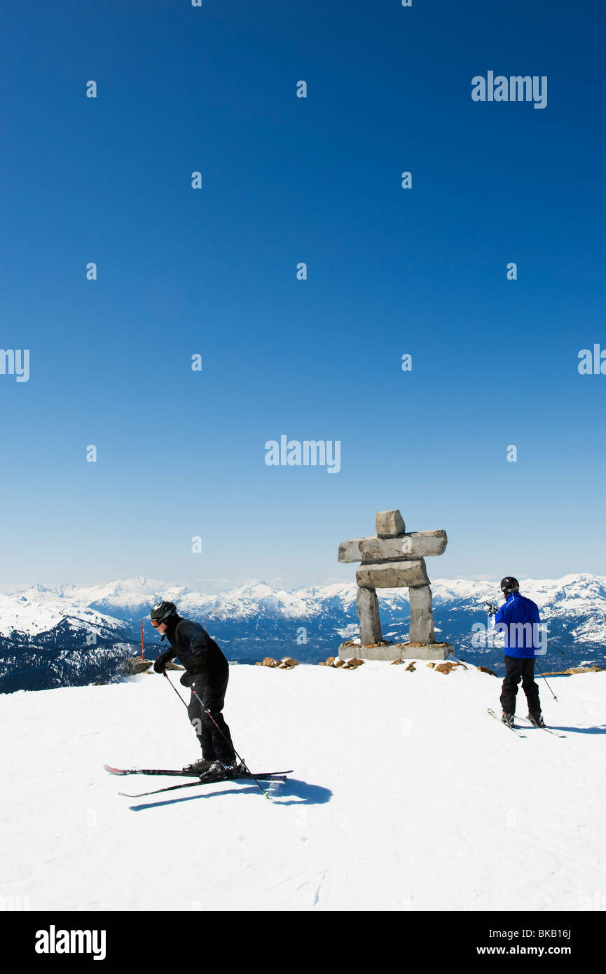 skiers near an Inuit Inukshuk stone statue Whistler mountain ski resort venue of the 2010 Winter Olympic Games Stock Photo