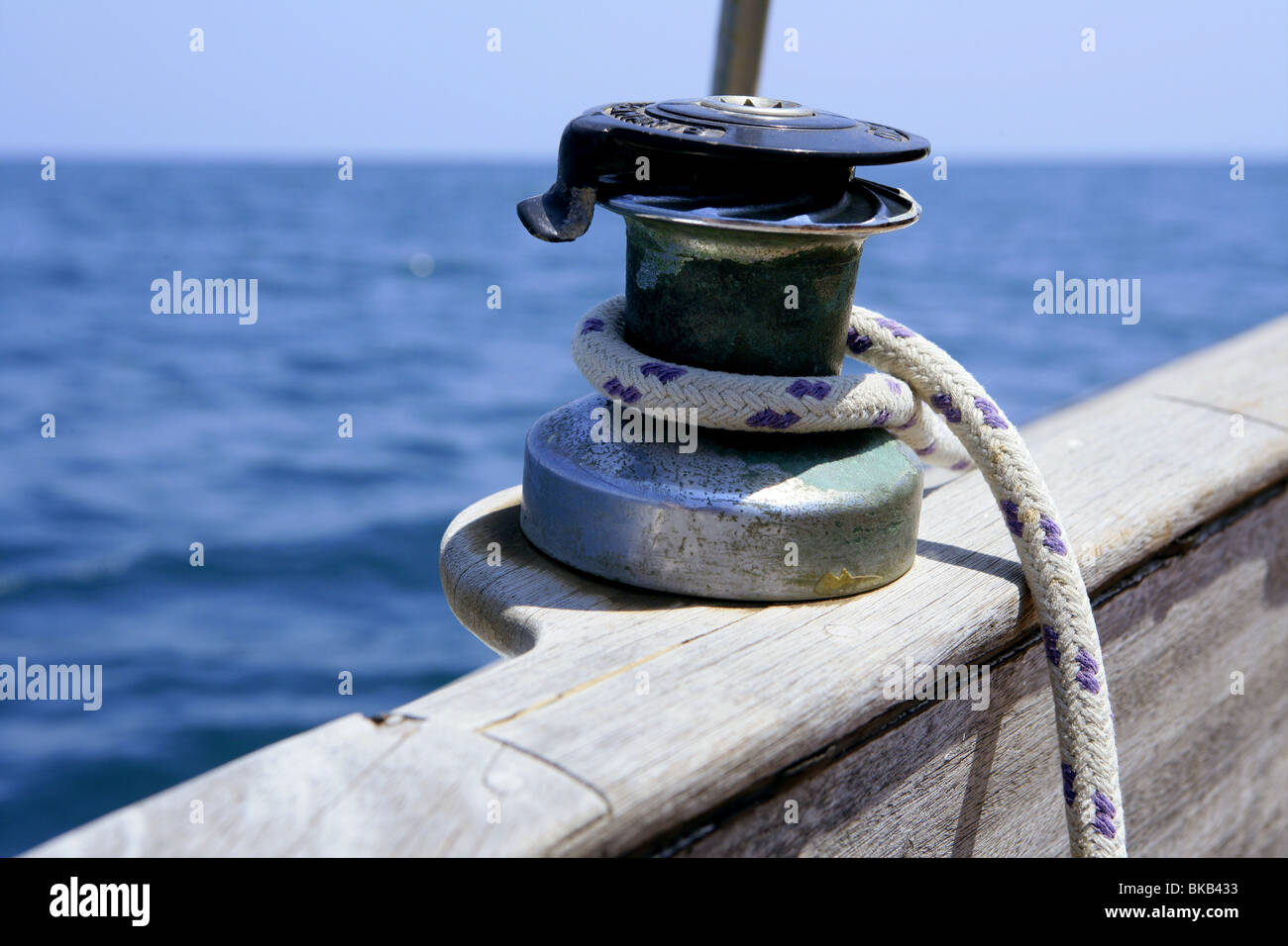 Sail boat winch with marine rope arround. Wooden sailboat Stock Photo