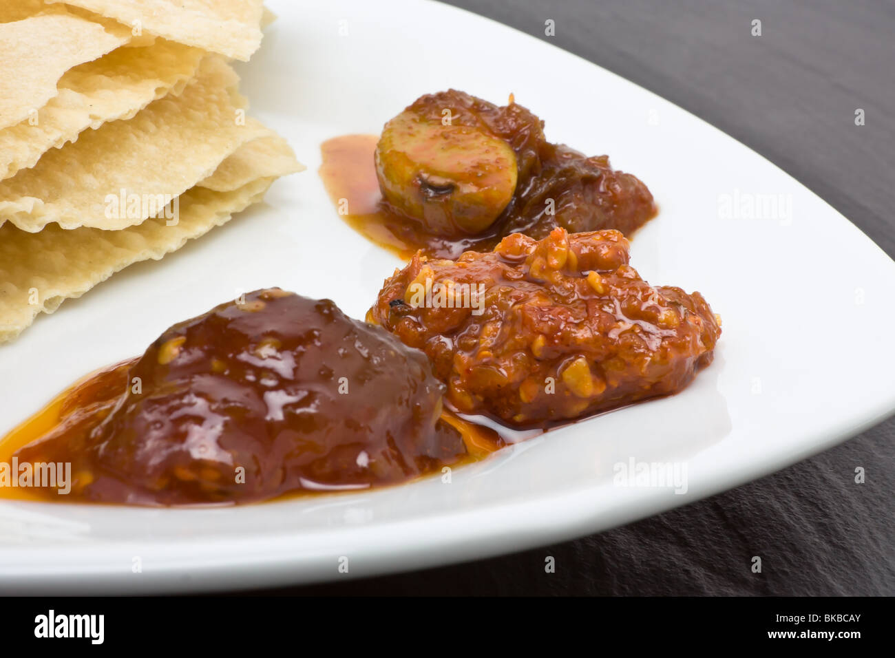 Traditional indian hors d'oeuvres of popadom and spicy pickles. Stock Photo
